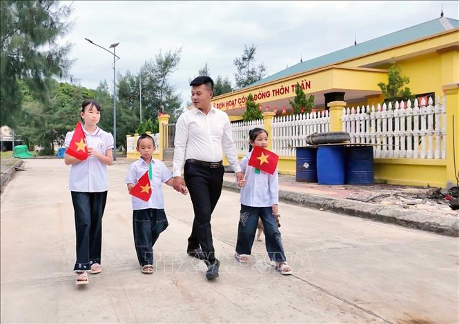 Thầy giáo đưa đón 3 học sinh đến lớp. Ảnh: TTXVN phát